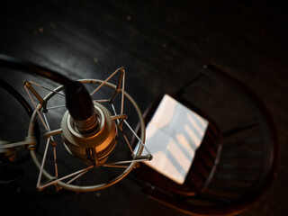 Fototapeta na wymiar Top View of Vienna Chair in Dimly Lit Room: Papers Scatter Across Seat, Microphone Nearby for Recording - Atmospheric Home Studio Setup
