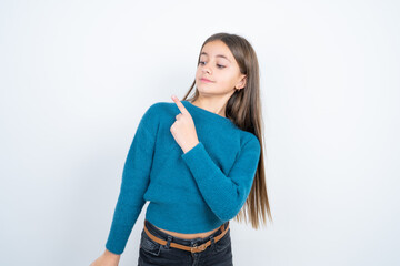 Young beautiful teen girl wearing blue T-shirt Pointing aside worried and nervous with forefinger,...