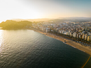 Aerial view of Lloret del Mar City. Mediterranean coastal town in Catalonia, Spain. One of the most popular Costa Brava beaches and travel destination. Panoramic view of all region Sunset warm colours