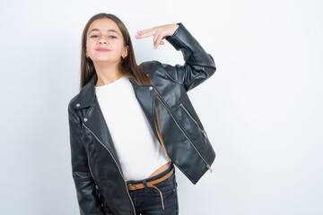 Young beautiful teen girl wearing biker jacket foolishness around shoots in temple with fingers...