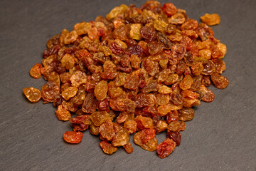 pile of brown raisins on a stone counter.