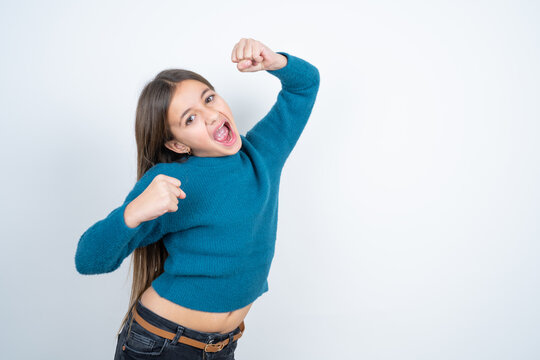 Profile photo of excited Young beautiful teen girl wearing blue T-shirt good mood raise fists screaming rejoicing overjoyed basketball sports fan supporter