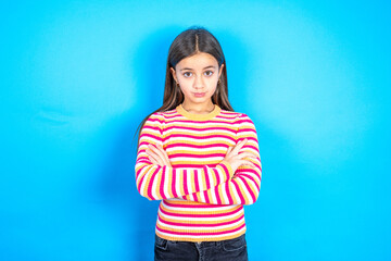 Confident Young kid girl wearing striped t-shirt with arms crossed looking to the camera