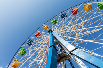 Carousel "Ferris Wheel" against a blue clear sky. Place for inscription.