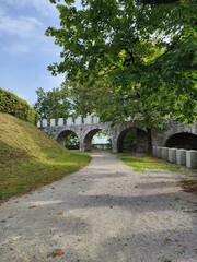 Fototapeta na wymiar Arched stone bridge in the park in Ljubljana