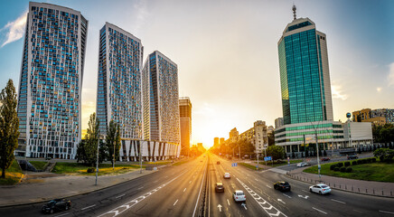 Fototapeta na wymiar Three modern apartment building and avenue at sunset. Kyiv. Ukraine
