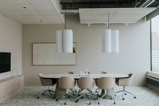 Empty conference table with chairs and pendant light in board room