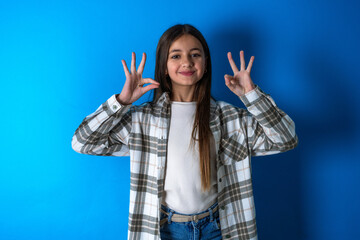 Beautiful kid girl wearing plaid shirt relax and smiling with eyes closed doing meditation gesture with fingers. Yoga concept.