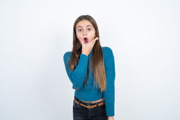 Obraz premium beautiful kid girl wearing blue sweater Looking fascinated with disbelief, surprise and amazed expression with hands on chin