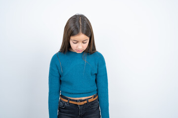 beautiful kid girl wearing blue sweater looking sleepy and tired, exhausted for fatigue and hangover, lazy eyes in the morning.