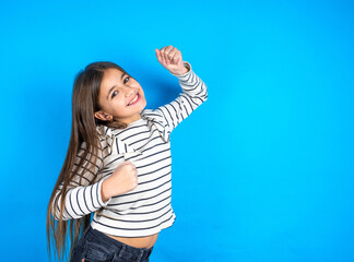 Profile photo of excited beautiful kid girl wearing plaid shirt good mood raise fists screaming rejoicing overjoyed basketball sports fan supporter