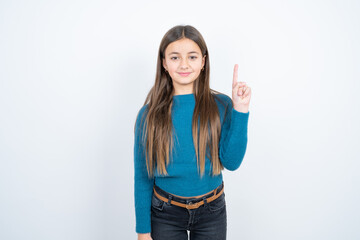 beautiful kid girl wearing blue sweater showing and pointing up with finger number one while smiling confident and happy.