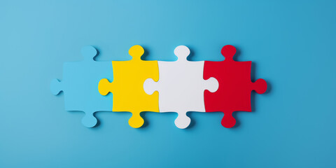 World Autism Awareness Day or month concept. Creative design for April 2. Blue, red, yellow  jigsaw puzzles, symbol of awareness for autism spectrum disorder on blue background. Top view, copy space