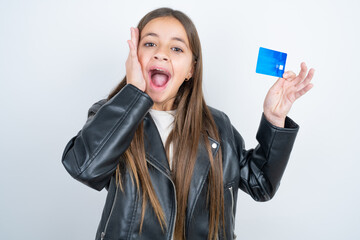Astonished positive Young beautiful teen girl wearing biker jacket arm face hold bank plastic card...