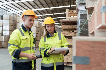Male and female warehouse worker working in lumber storage warehouse. Workers working in timber storage warehouse. Manufacturing and warehouse concept