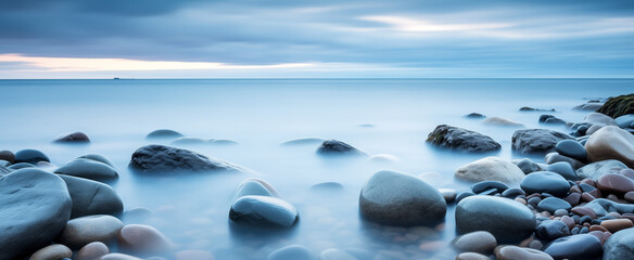 Ethereal seascape with smooth pebbles and misty horizon - obrazy, fototapety, plakaty