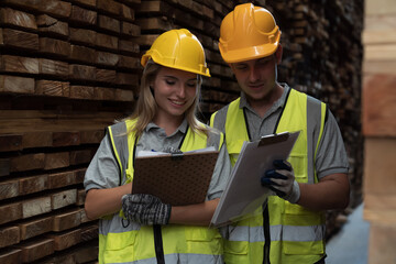 Male and female warehouse worker working in lumber storage warehouse. Workers working in timber storage warehouse. Manufacturing and warehouse concept