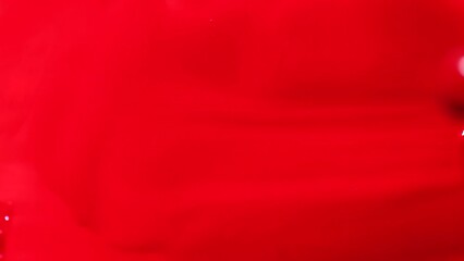 Red nail polish drops, manicure concept. Spilled uv gel, enamel, varnish with brush on red color background, splash. Beauty salon, nail care product. Nail art. Top view, fashion backdrop 