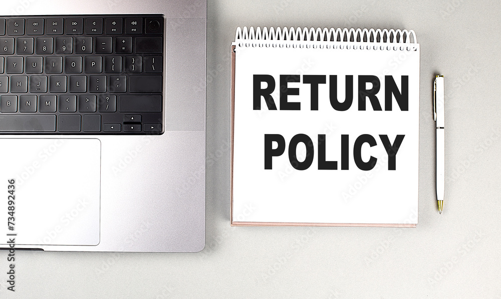 Poster return policy text on notebook with laptop and pen