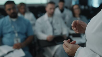 Close up shot of hands of female doctor gesticulating during speech in front of audience on medical conference - Powered by Adobe