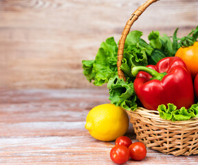 Basket with vegetables and greenery on a wooden table. Healthy eating, harvest, Thanksgiving Day. Close-up. Copy space.