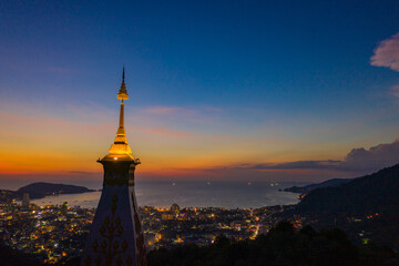 aerial view scenery sunset above pagoda of Doi Thepnimit temple on the highest of Patong mountain..The lights twinkle at twilight background..Scene of Colorful romantic sky sunset, beautiful pagoda. - obrazy, fototapety, plakaty