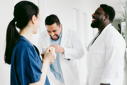 Cheerful multiracial medical team enjoying during coffee break at hospital