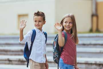 Kids go to school and waving goodbye to their mother - Back to school concepts. Kids saying goodbye...