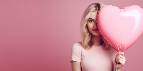 girl holding pink heart shaped balloon on pink banner. Valentine's day concept