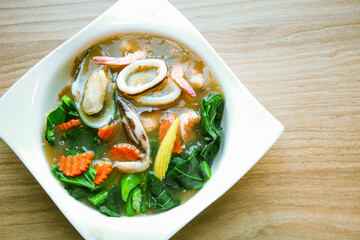 Wide Rice Noodles with Seafood in Gravy Sauce, or what we call Rad-Na Taley, served on a white...
