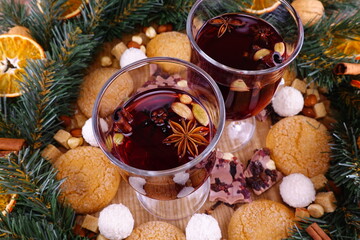 Festive composition on the theme of Christmas with mulled wine, a wreath of coniferous branches and orange slices and sweets.