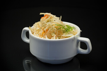 sauerkraut with carrots and spices in a white bowl