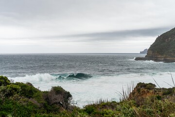 Fototapeta na wymiar waves breaking on rocks in on the coast by the sea in tasmania australia in summer