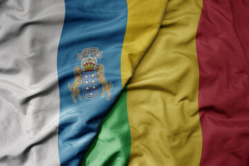 big waving national colorful flag of mali and national flag of canary islands .