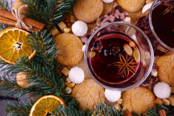 Obraz na płótnie Canvas Festive composition on the theme of Christmas with mulled wine, a wreath of coniferous branches and orange slices and sweets.