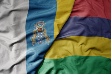 Fototapeta premium big waving national colorful flag of mauritius and national flag of canary islands .