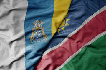 Fototapeta premium big waving national colorful flag of namibia and national flag of canary islands .
