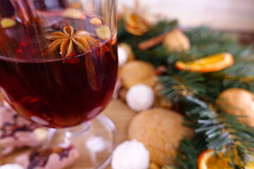 Festive composition on the theme of Christmas with mulled wine, a wreath of coniferous branches and orange slices and sweets.