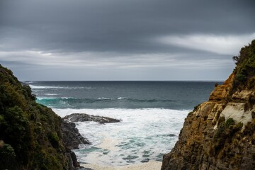waves breaking on rocks in on the coast by the sea in tasmania australia in summer