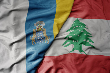 big waving national colorful flag of lebanon and national flag of canary islands .