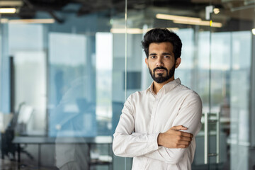 Portrait of a serious and successful young Indian businessman. of a specialist standing in the office with his arms crossed on his chest, confidently looking into the camera