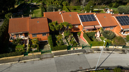Aerial view on small terraced villas built in a residential area. All houses have their own garden.
