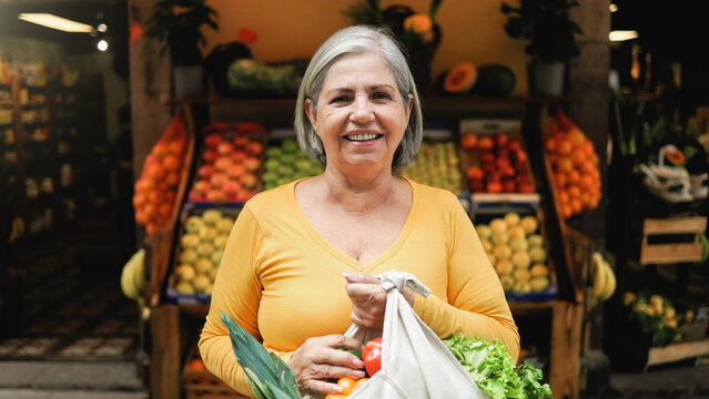 Latin senior woman shopping at farm market. Customer buying at grocery store. Small business concept. Black and white editing