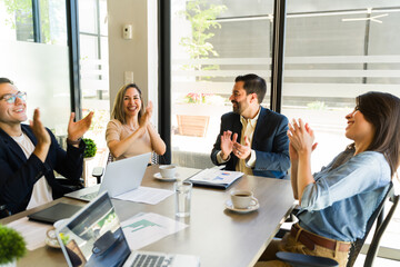 Businesspeople clapping and celebrating during a business meeting