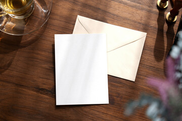 Envelope back side and blank card invitation Mockup. Top view on wooden background. with clipping path