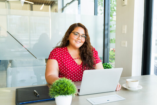 Happy overweight businesswoman working with a laptop computer and smiling