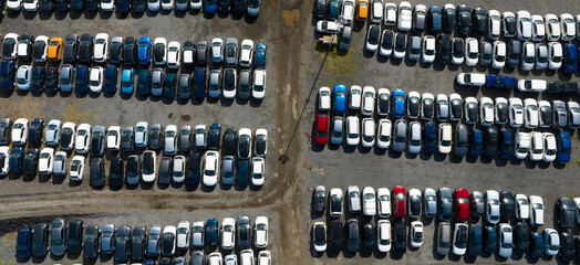 Perpendicular aerial view of many cars parked and ready for sale and distribution on the...
