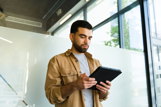 Young businessman in casual clothing using a tablet computer for work