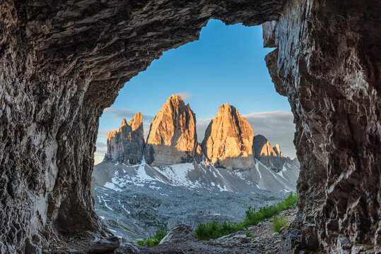 View from the cave on famous mountain peaks Tre Cime di Lavaredo, Sexten Dolomites, South Tyrol, Italy at sunrise. Drei Zinnen mountains in national park, Trentino Alto Adige