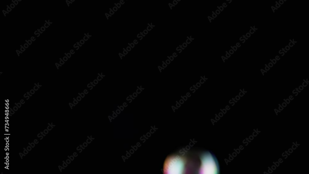Poster lot of large colorful soap bubbles fly on a black background and burst. blowing. splash, foam. fast 